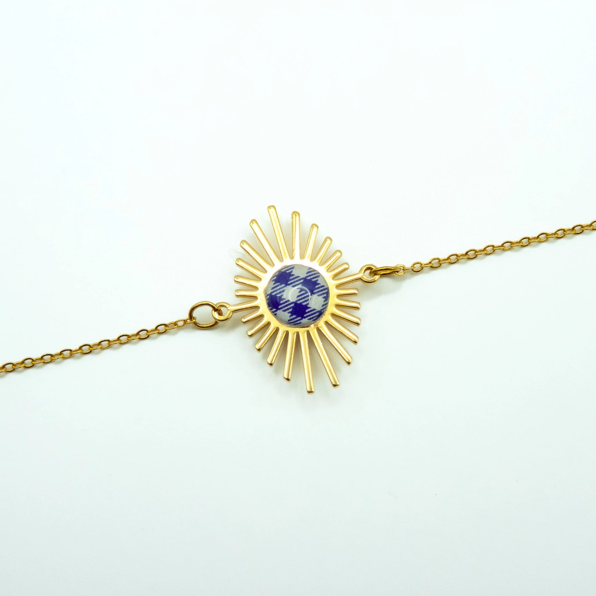 Bracelet soleil doré avec motif carreau de Vichy bleu, création Studio Sōzō, photographié sur fond blanc