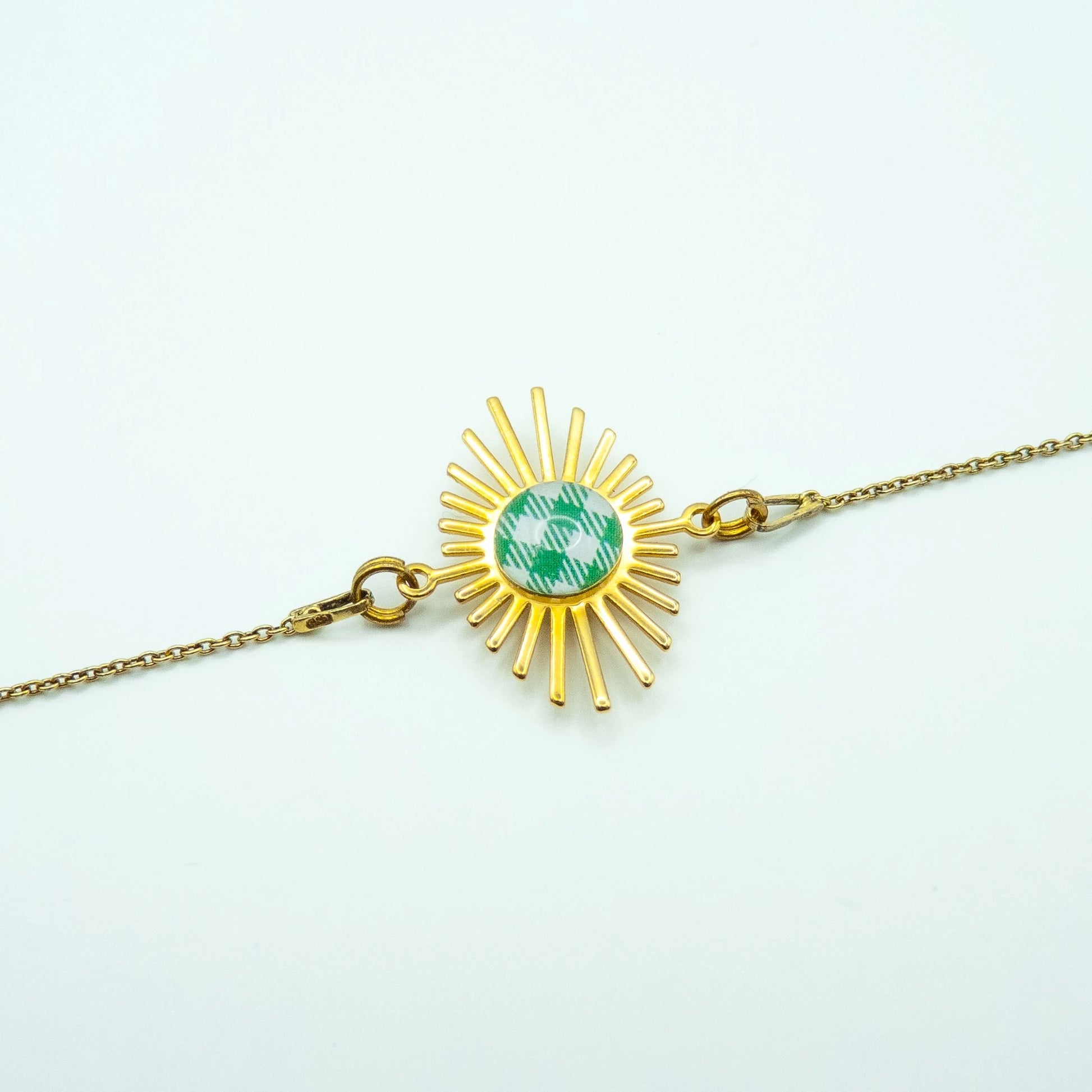 Bracelet Hélios Studio Sōzō avec motif carreau de Vichy vert – bijou doré fait main à Vichy, illustration au centre d’un intercalaire soleil